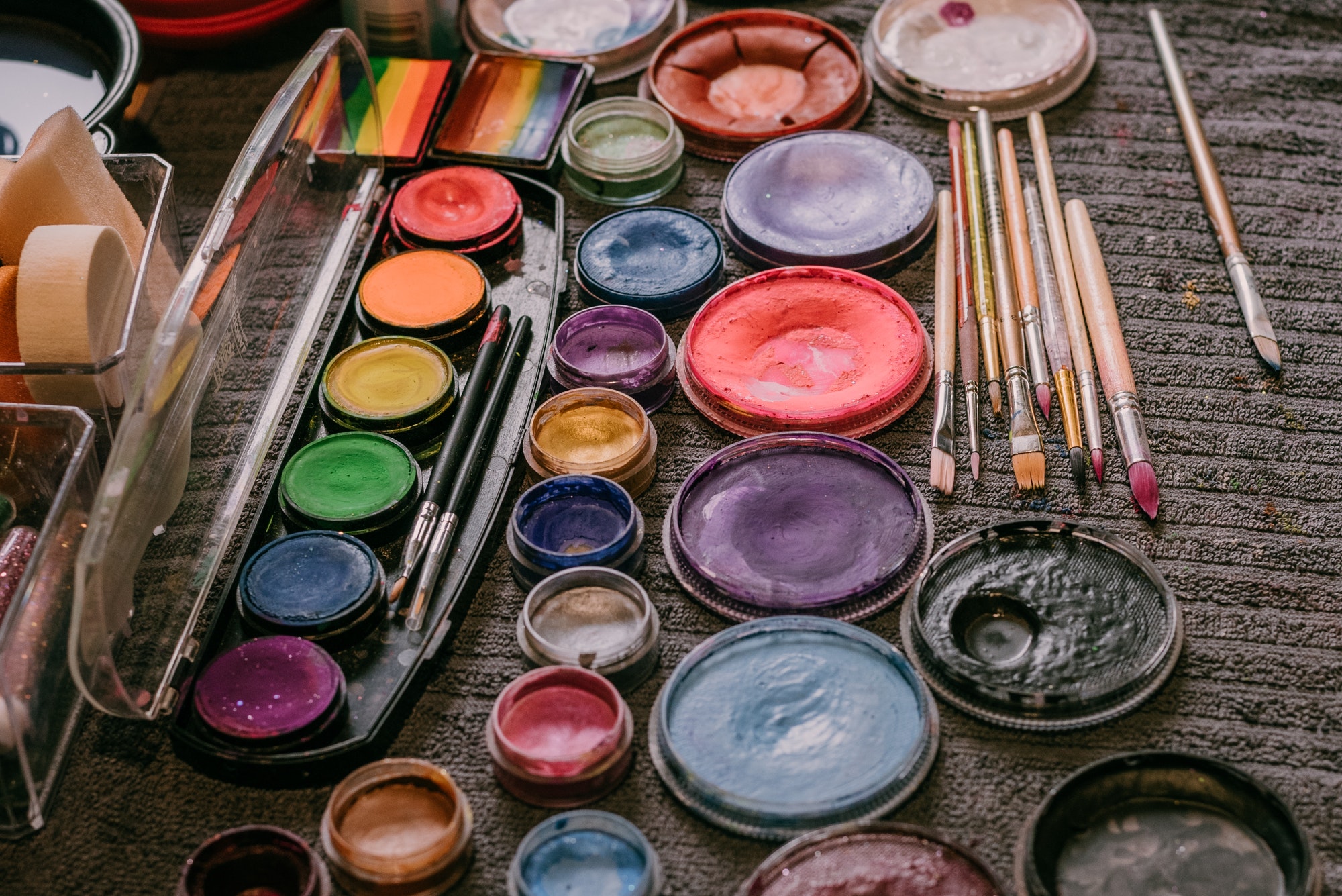 Art supplies, paint brushes and watercolors on the table.